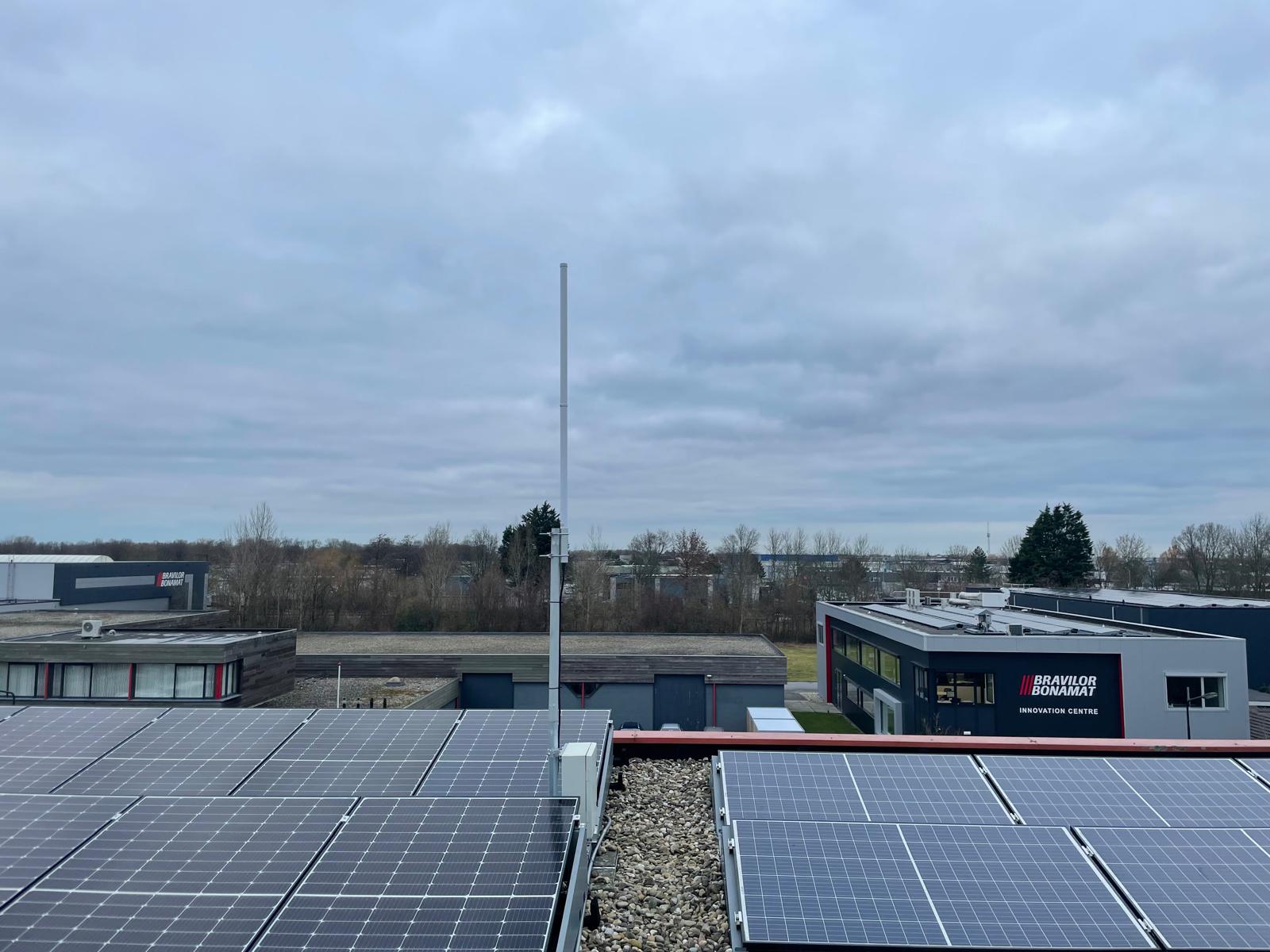 Gateway antenna on a rooftop with solar panel arrays